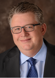 Jeff Headshot Wearing blue tie, shirt, and sport coat.